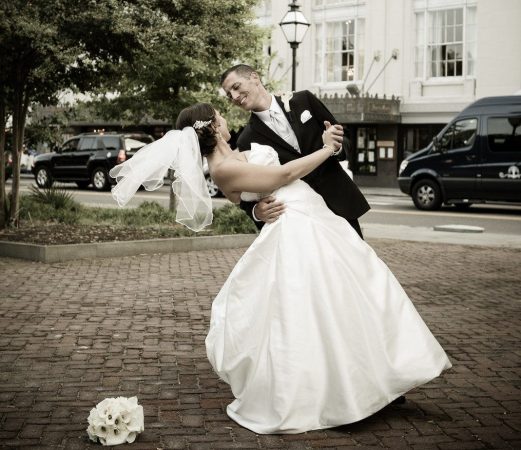 A bride and groom in front of the hotel.
