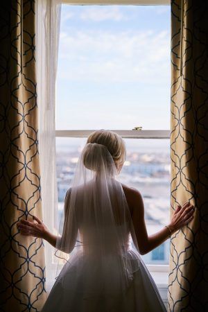 A bride looks out a window.