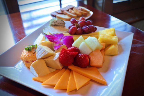 A plate with cheese and fruit.