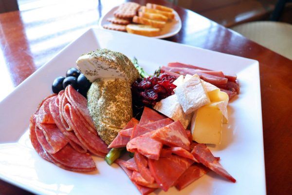 A square plate with a variety of meats and cheeses.