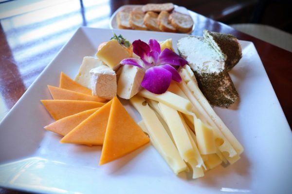 A large plate with a variety of cheeses.