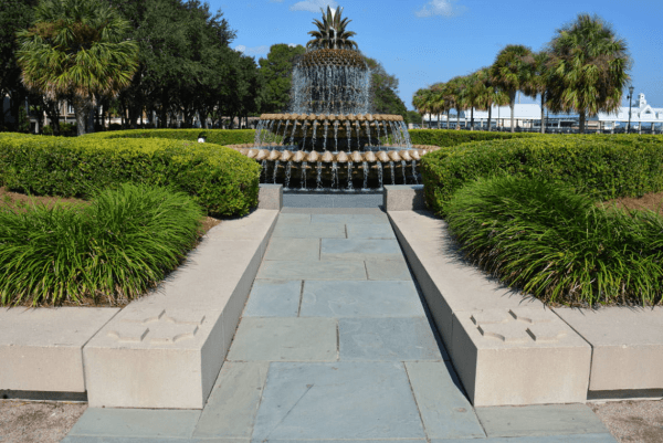 A fountain that represents a pineapple has water cascading down it.