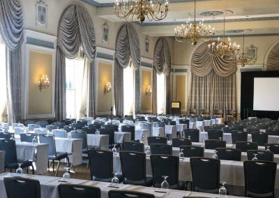 Our colonial ballroom is set with a lot of long tables with blue chairs.