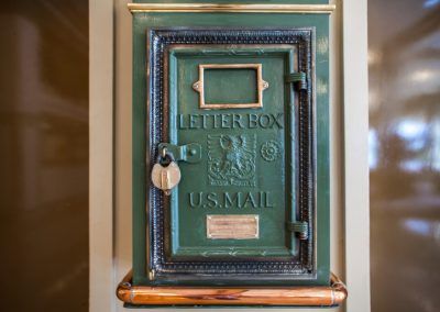 An old green letter box with a golden latch.