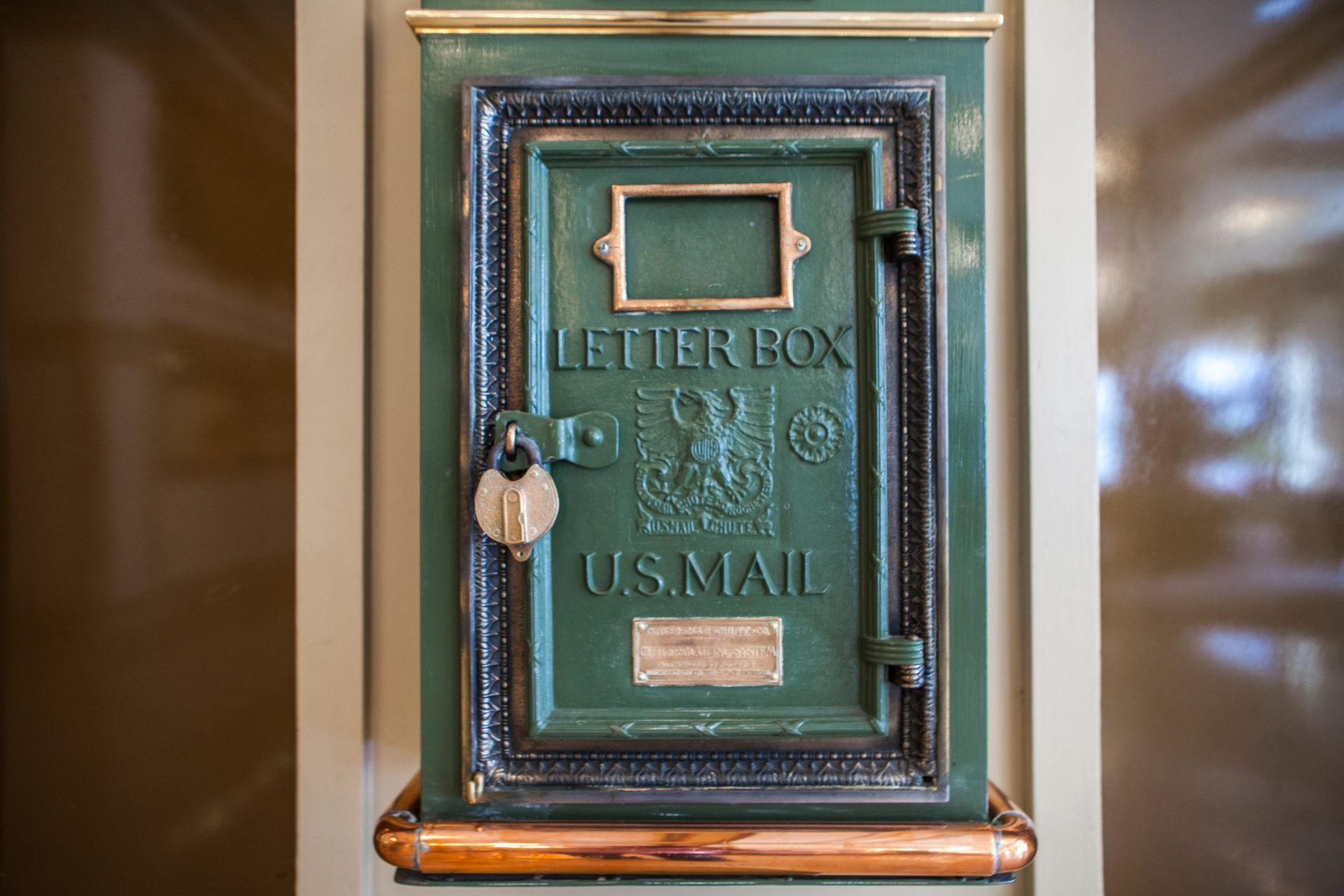 An old green letter box with a golden latch.