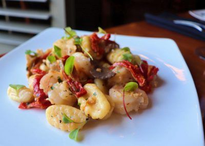White gnocchi with red peppers and mushrooms and shrimp.