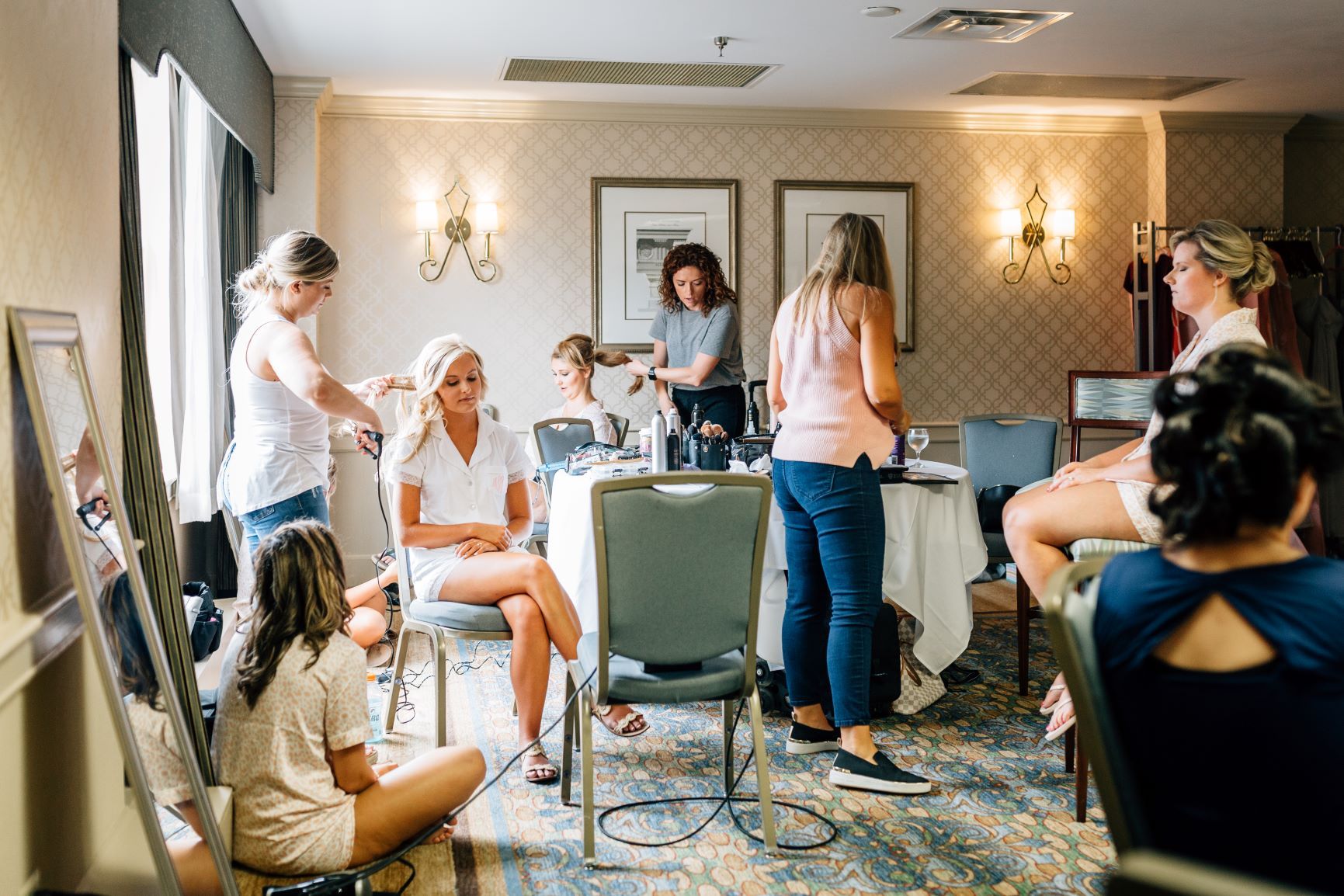 A bridal party gets ready in a room.