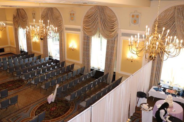A ballroom is being set up for a large wedding celebration.