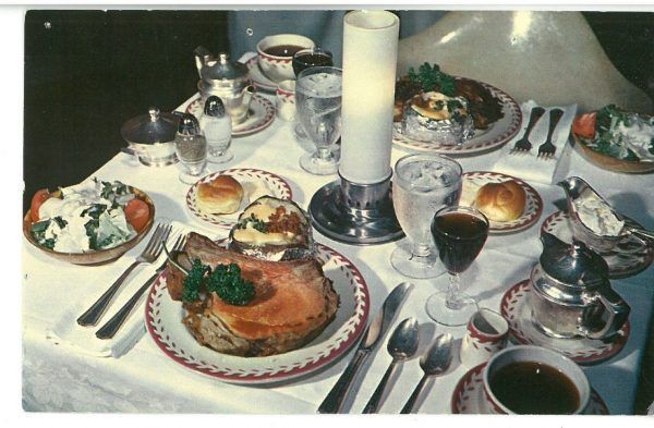 A dinner table is set with a meal for two people.
